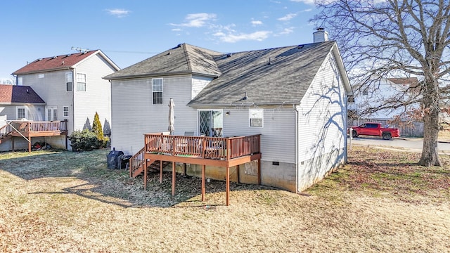 rear view of house featuring a wooden deck and a yard