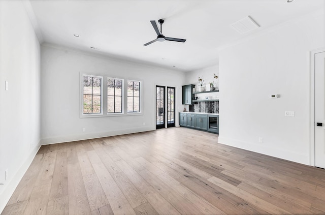 unfurnished living room featuring ceiling fan, ornamental molding, and light wood-type flooring