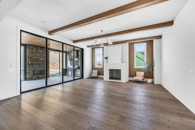 unfurnished living room featuring an inviting chandelier, dark wood-type flooring, and a fireplace