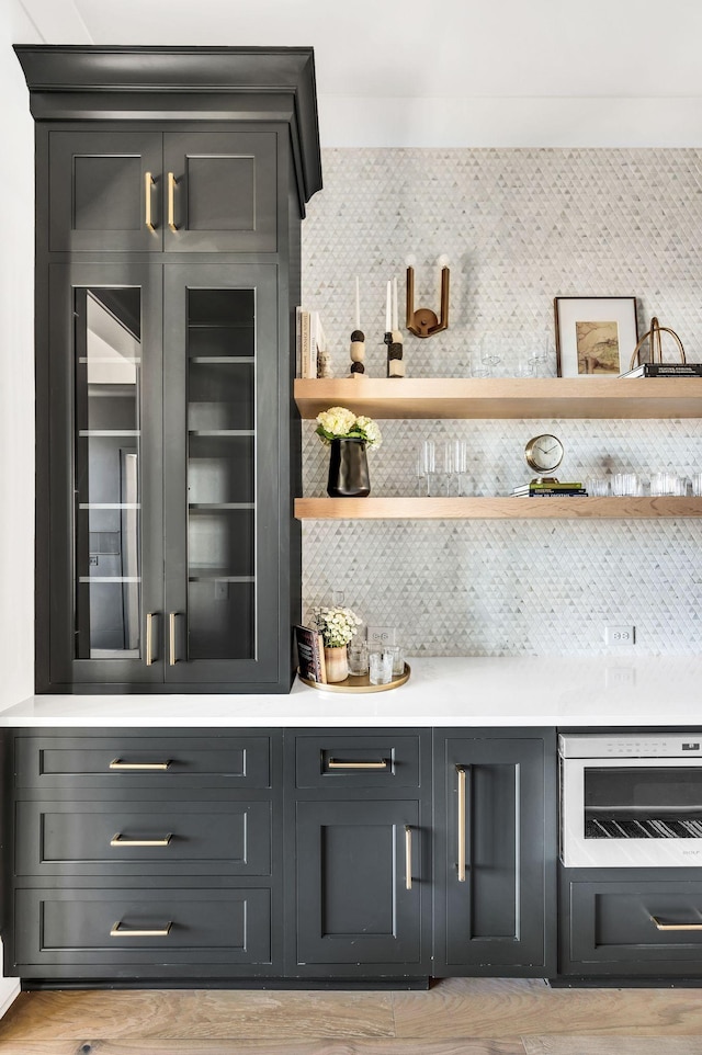 bar with backsplash and light wood-type flooring