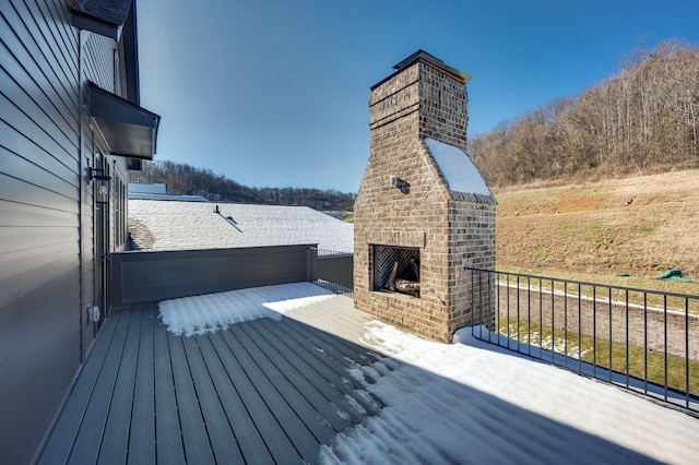 wooden deck featuring an outdoor brick fireplace