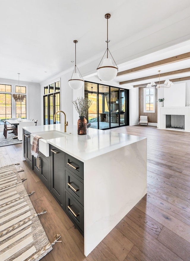 kitchen featuring pendant lighting, light hardwood / wood-style flooring, a chandelier, and a spacious island