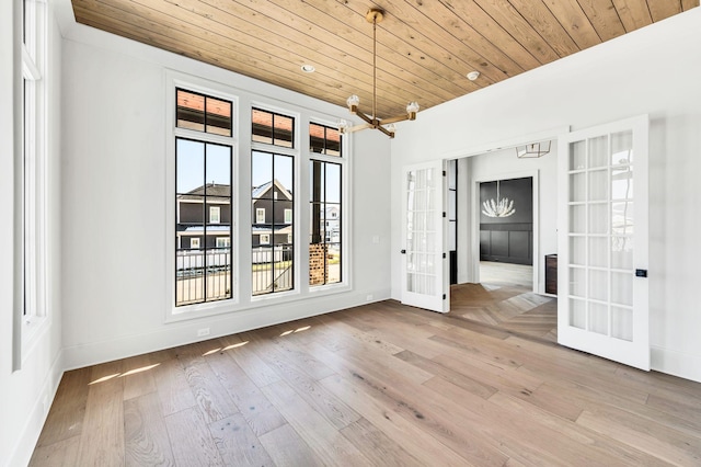 unfurnished room featuring wooden ceiling, light hardwood / wood-style floors, and french doors