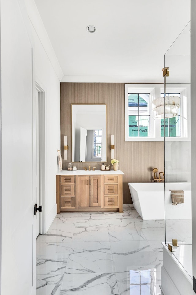 bathroom with vanity, crown molding, and a tub