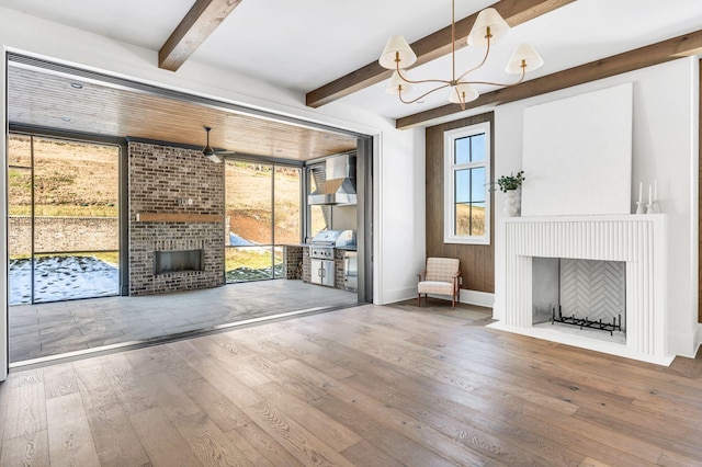 unfurnished living room with hardwood / wood-style flooring, a fireplace, and beamed ceiling