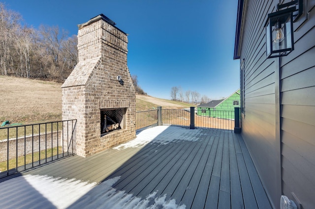 deck with an outdoor brick fireplace