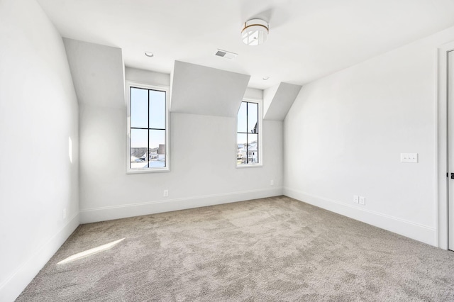 additional living space with lofted ceiling and light carpet