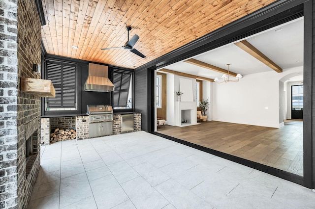 view of patio / terrace featuring ceiling fan, an outdoor kitchen, a grill, and a fireplace