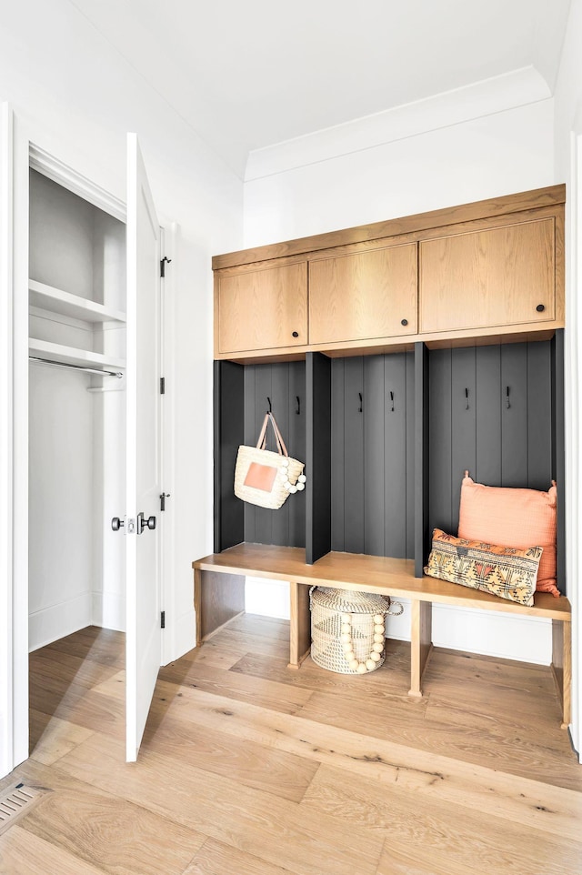 mudroom featuring ornamental molding and light hardwood / wood-style flooring