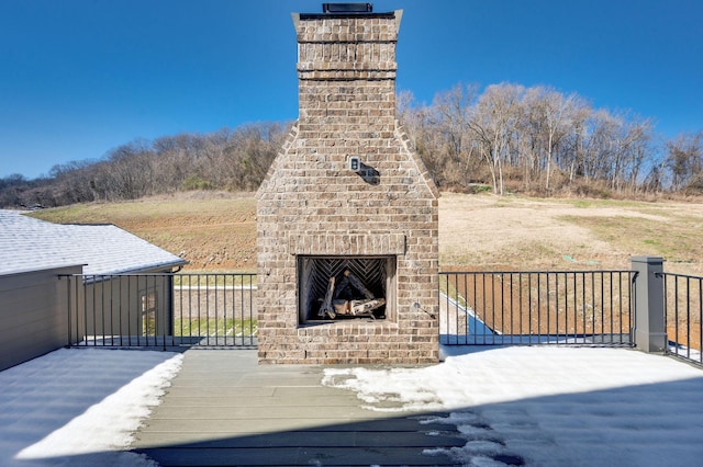 wooden terrace with an outdoor brick fireplace