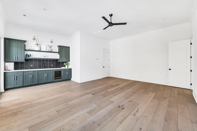 kitchen with crown molding, ceiling fan, backsplash, wine cooler, and light wood-type flooring