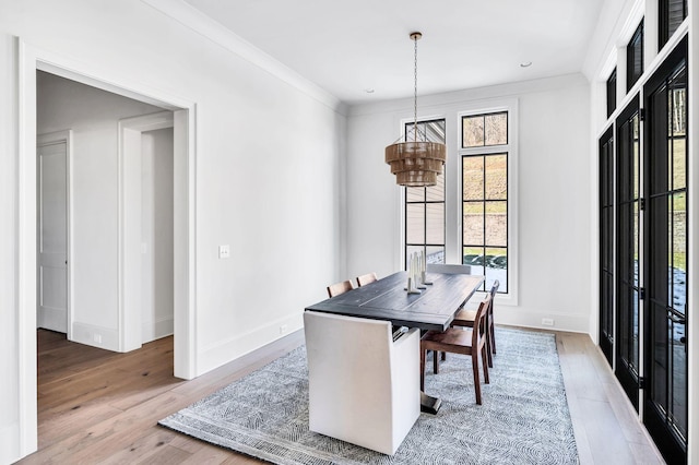 dining space featuring wood-type flooring and ornamental molding