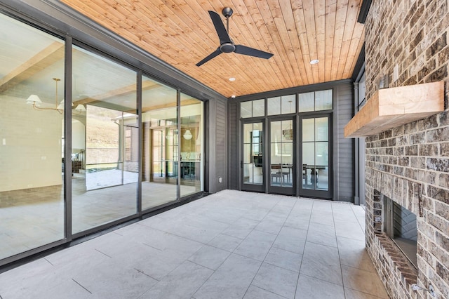 interior space with an outdoor brick fireplace and ceiling fan