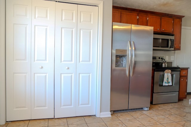 kitchen with appliances with stainless steel finishes and light tile patterned floors