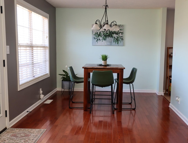 dining room featuring dark hardwood / wood-style flooring, a wealth of natural light, and an inviting chandelier