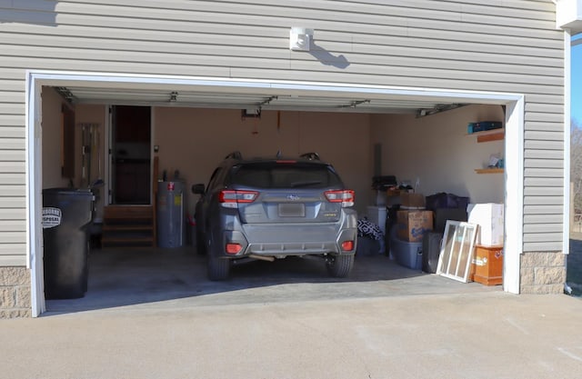 garage featuring a garage door opener and water heater