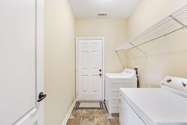 washroom with separate washer and dryer and a textured ceiling