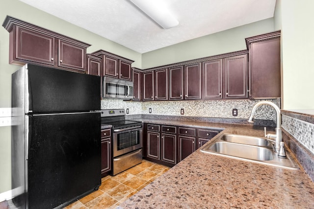 kitchen featuring stainless steel appliances, sink, light tile patterned floors, and decorative backsplash