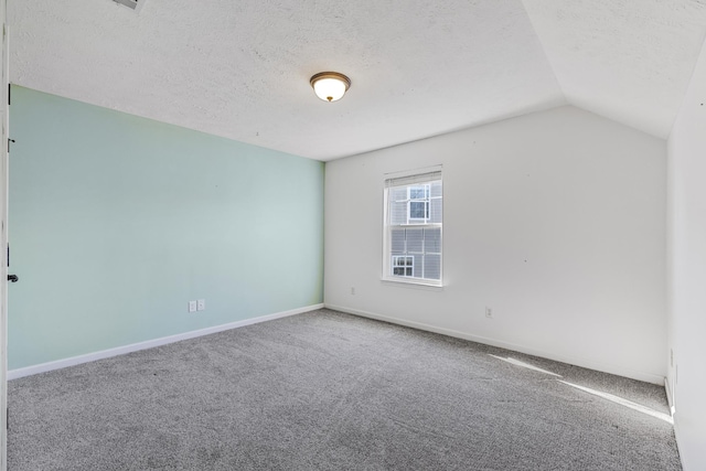 carpeted spare room with lofted ceiling and a textured ceiling