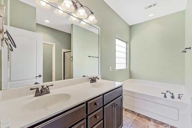 bathroom with vanity and shower with separate bathtub