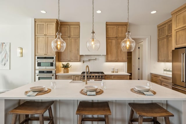 kitchen with tasteful backsplash, stainless steel appliances, a breakfast bar, and a large island with sink