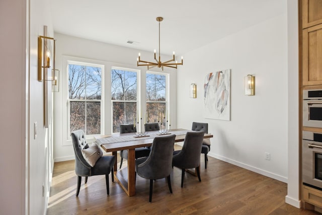 dining area featuring dark hardwood / wood-style floors and a chandelier