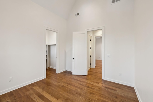 unfurnished bedroom featuring dark hardwood / wood-style floors and high vaulted ceiling