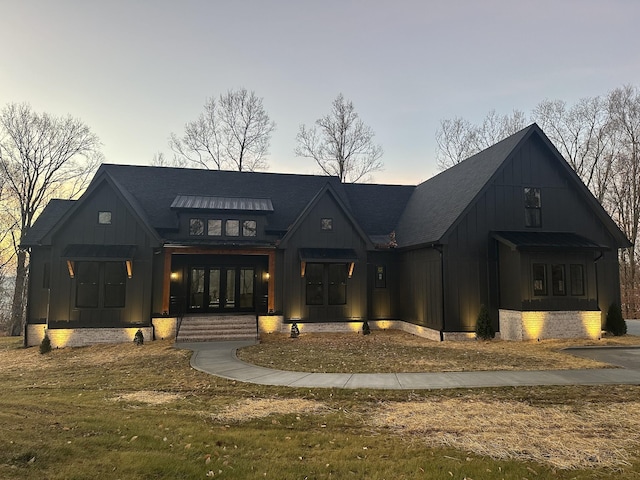 modern farmhouse style home with a yard and french doors