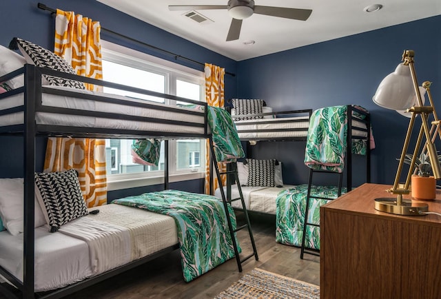 bedroom featuring multiple windows, hardwood / wood-style floors, and ceiling fan