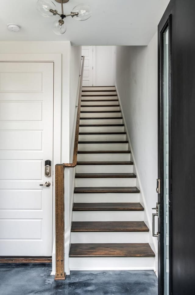 staircase featuring concrete floors