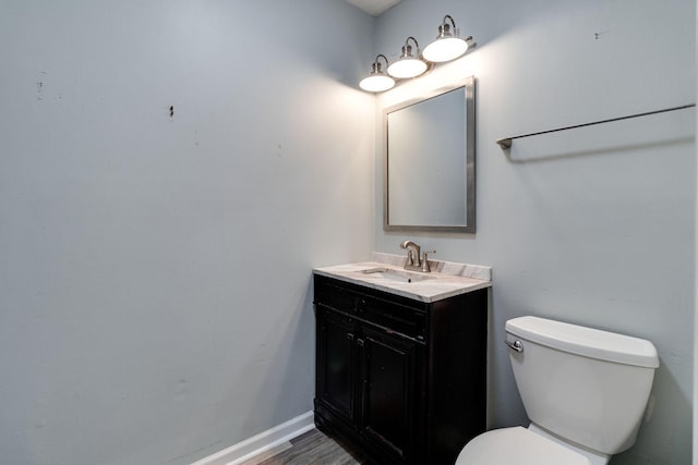 bathroom with hardwood / wood-style flooring, vanity, and toilet