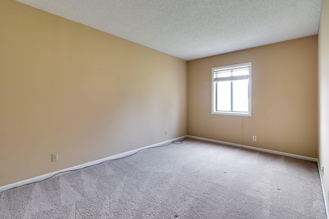 empty room with carpet floors and a textured ceiling