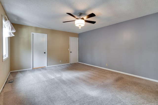 carpeted empty room with ceiling fan and a textured ceiling