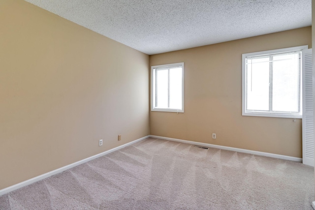 carpeted spare room with a textured ceiling