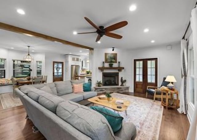 living room with dark hardwood / wood-style flooring, ceiling fan, beam ceiling, and french doors