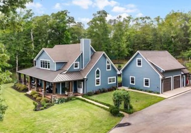 view of front of house featuring a garage, a front lawn, and covered porch