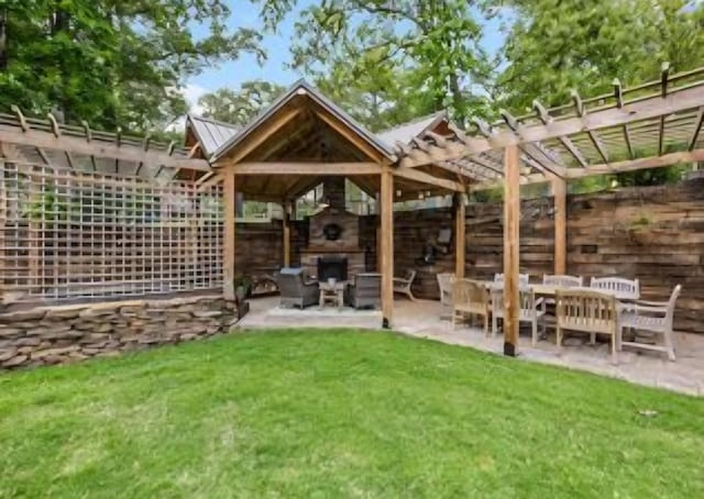 exterior space featuring a lawn, a fireplace, and a patio area