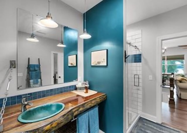 bathroom with tasteful backsplash, vanity, hardwood / wood-style floors, and an enclosed shower