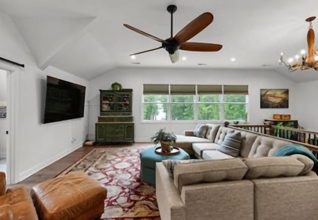 living room with hardwood / wood-style flooring, vaulted ceiling, and ceiling fan with notable chandelier