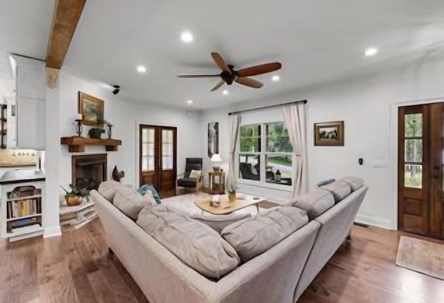 living room with plenty of natural light, dark hardwood / wood-style floors, ceiling fan, and french doors