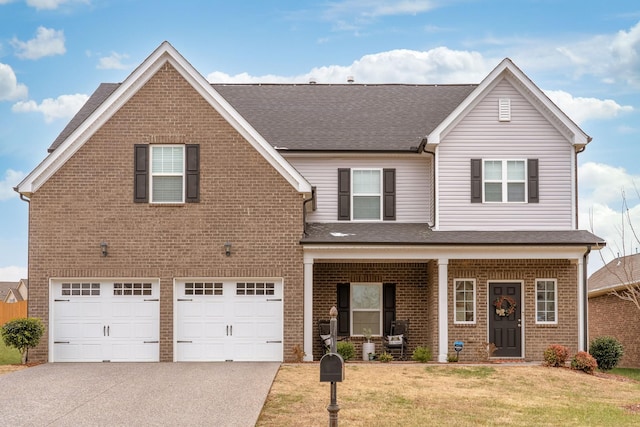 view of front of house with a garage, a porch, and a front lawn