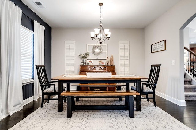 dining area with a notable chandelier, hardwood / wood-style flooring, and plenty of natural light