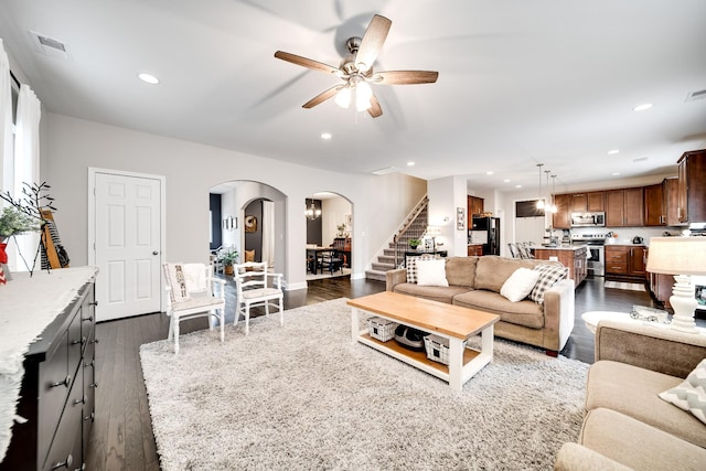 living room with ceiling fan and dark hardwood / wood-style flooring