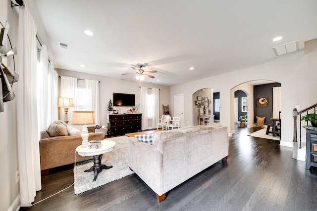 living room with dark wood-type flooring and ceiling fan