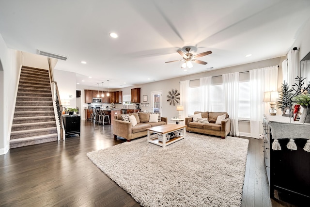 living room with dark hardwood / wood-style floors and ceiling fan