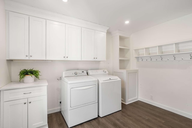 washroom with dark hardwood / wood-style floors, washing machine and dryer, and cabinets