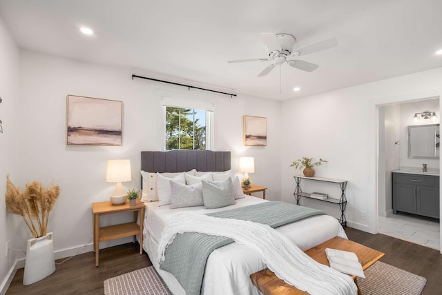 bedroom featuring ceiling fan, ensuite bathroom, dark hardwood / wood-style flooring, and sink