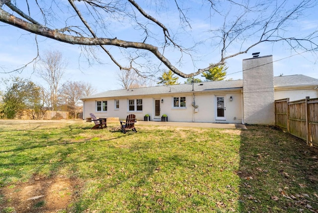 rear view of property featuring a yard and a patio area