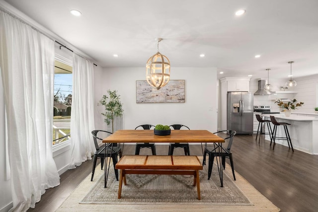 dining space featuring dark wood-type flooring, a notable chandelier, and a wealth of natural light