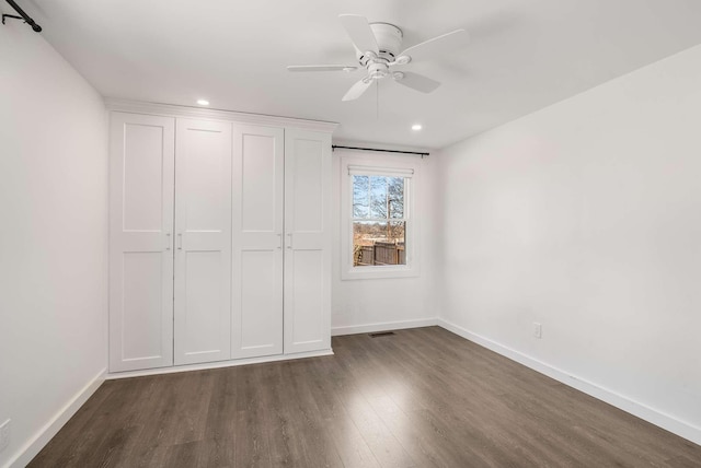 unfurnished bedroom featuring dark wood-type flooring and ceiling fan